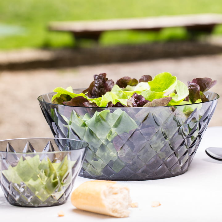 Les bols CRYSTAL de Koziol avec de la salade sur la table à manger en plein air.