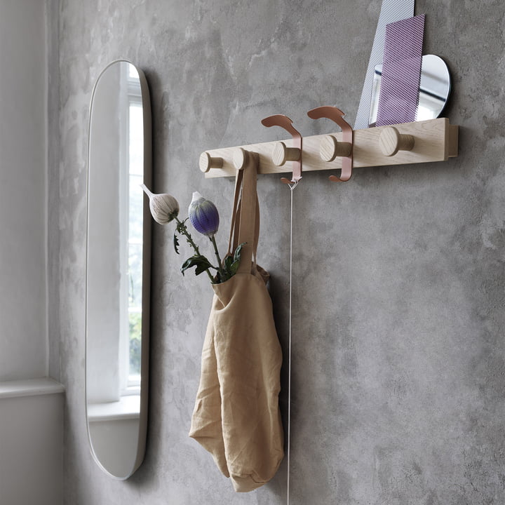 Le porte-manteau et le grand miroir encadré de Muuto dans le couloir moderne.