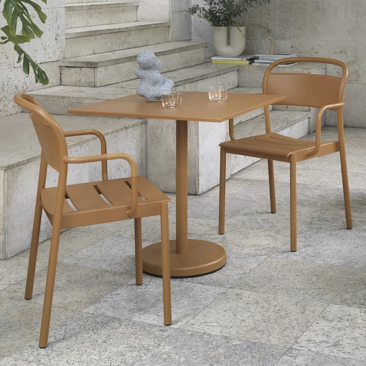 La table Linear Steel de Muuto avec les Linear Steel Armchairs sur une terrasse en pierre