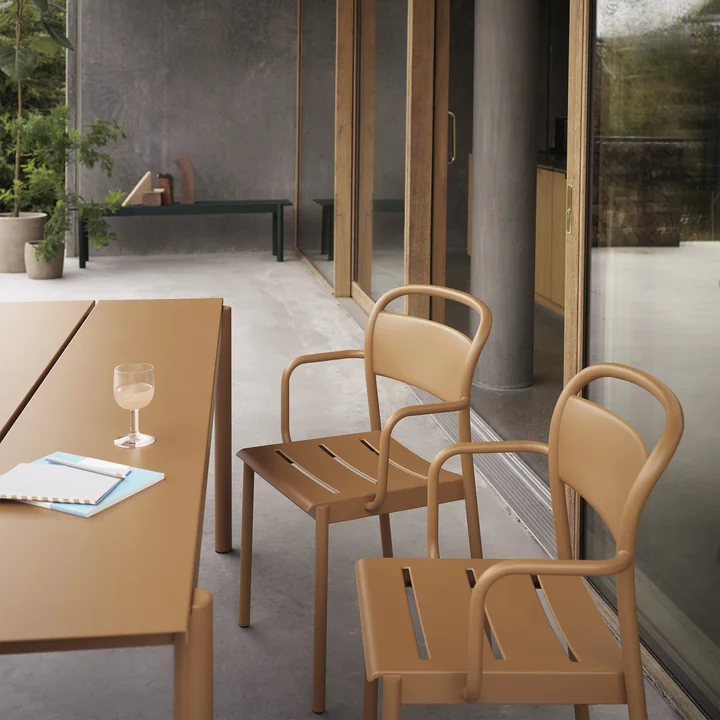 Le Linear Steel Armchair de Muuto à la table Linear Steel sur la terrasse