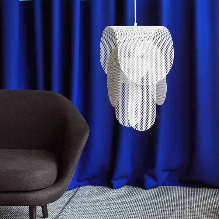 La lampe à suspension Superpose de Normann Copenhagen à côté d'un fauteuil noir