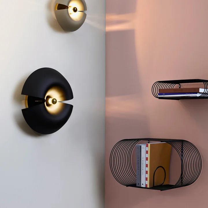 L'étagère murale aérienne et légère Curva de AYTM à côté de l'applique murale Cycnus