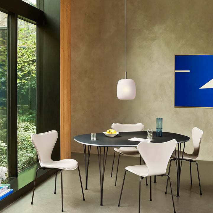 La lampe suspendue rose Maluma H350 de Fritz Hansen au-dessus de la table à manger noire